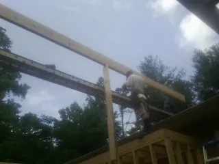 Carpenter setting a ridge beam over a new addition frame — Ice Dam Removal by Roofing Brothers in Park