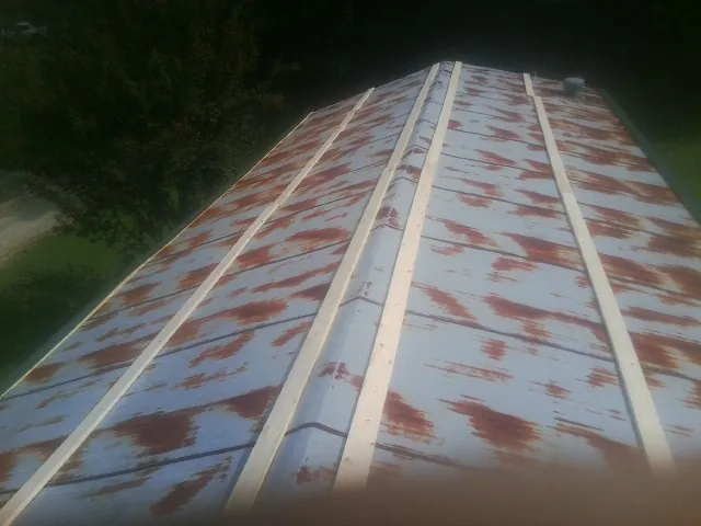 Rusted metal roof panels with new wood purlins before replacement — Storm Damage Roof Repair in Park by Roofing Brothers