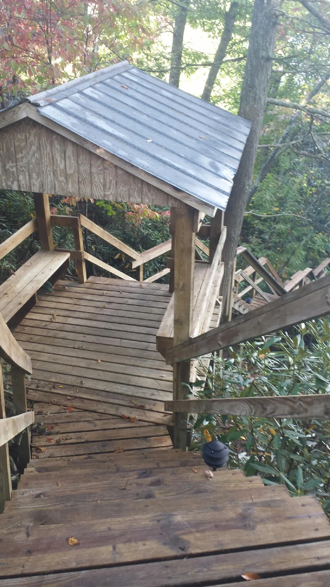 Metal roofed shelter over wooden steps on a wooded walkway — Skylight Repair & Installation work by our crew in Park